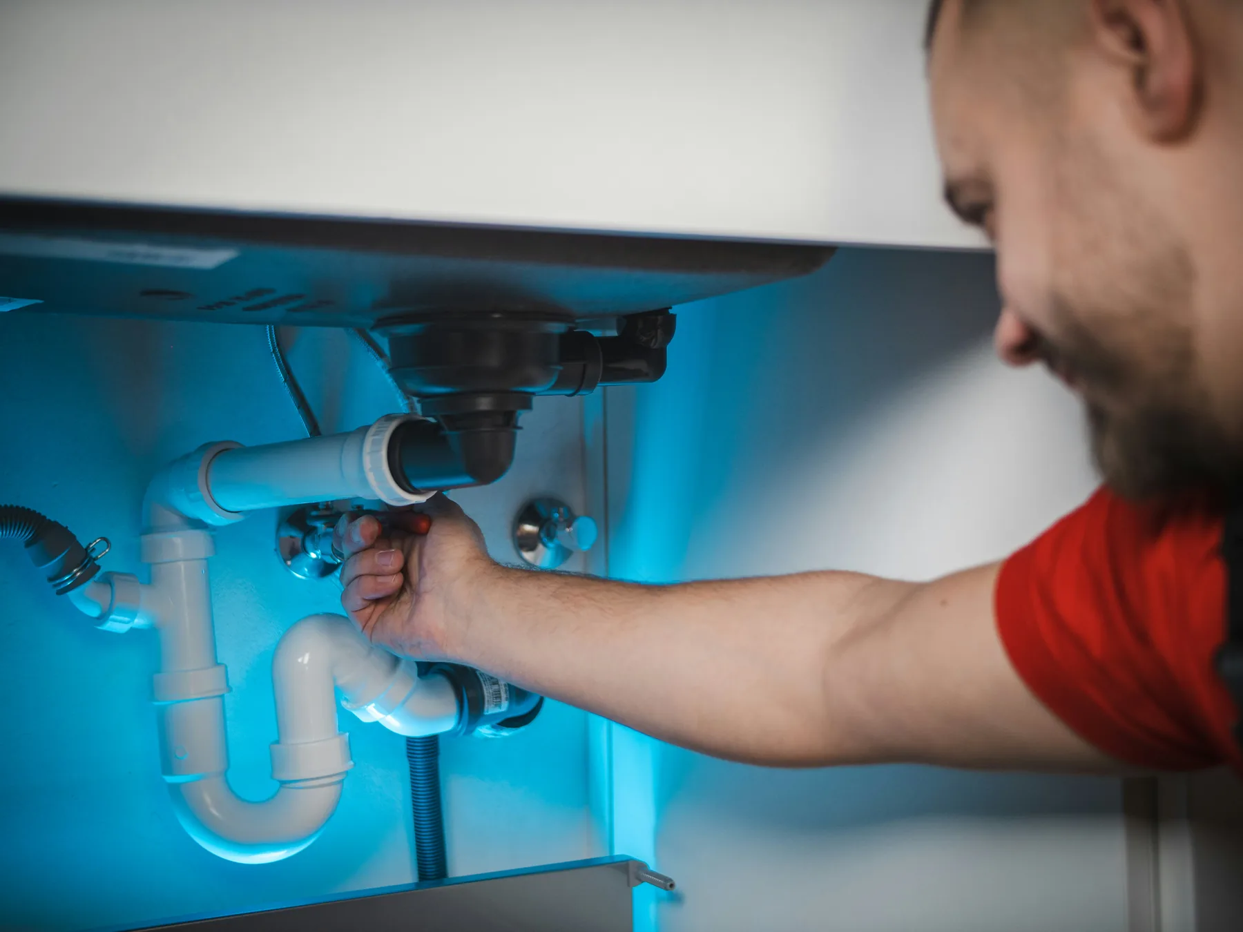 Licensed plumber repairing a residential sink connection